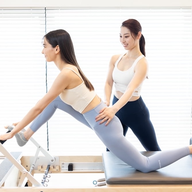 マシンピラティスのレッスンを受ける女性