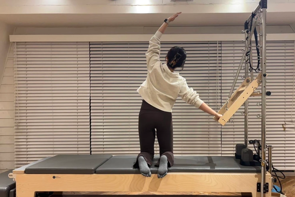 下北沢のピラティススタジオ Muniのリフォーマーフリーを受ける女性