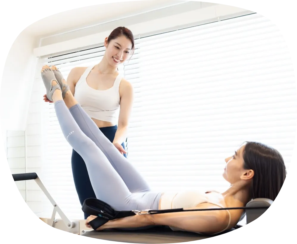 下北沢のピラティススタジオ Muniのリフォーマーベーシックレベル1.5プログラムを受ける女性