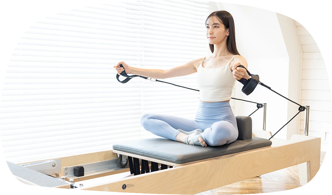 下北沢のピラティススタジオ MuniのMuniのリフォーマーフリーを受ける女性